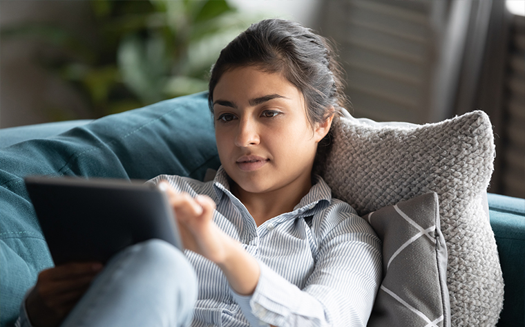 young woman looking at tablet on the couch