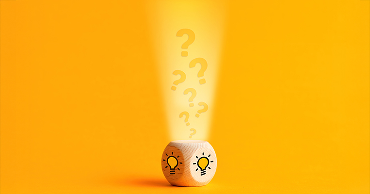 Question mark icons are filling into a wooden cube